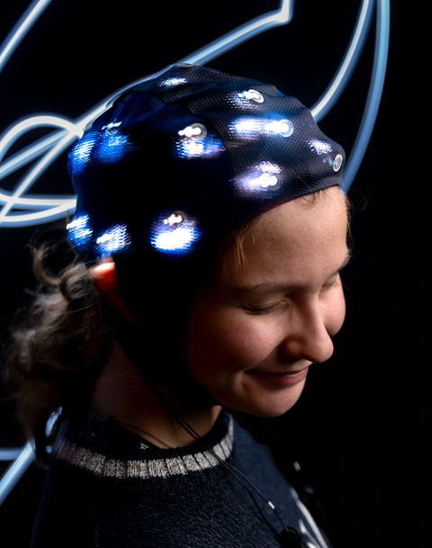 student with brain cap and glowing wires