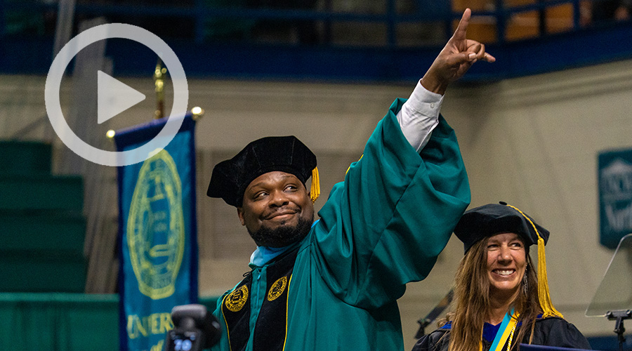 A photo of Sameon West celebrating and pointing during UNCW's December 2022 Commencement.