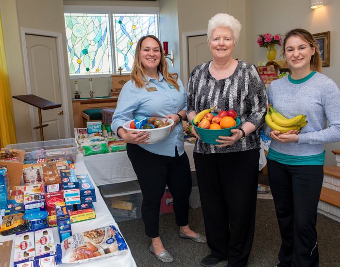 Jaime Russell and others holding donated food