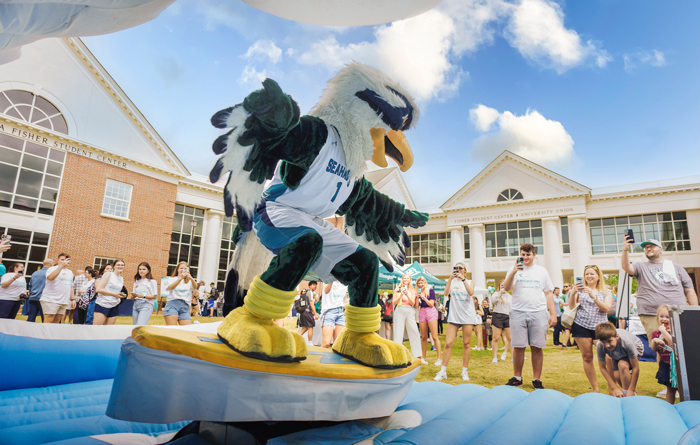 Sammy C. Hawk rides the surf simulator during the Seahawks Give kickoff event.